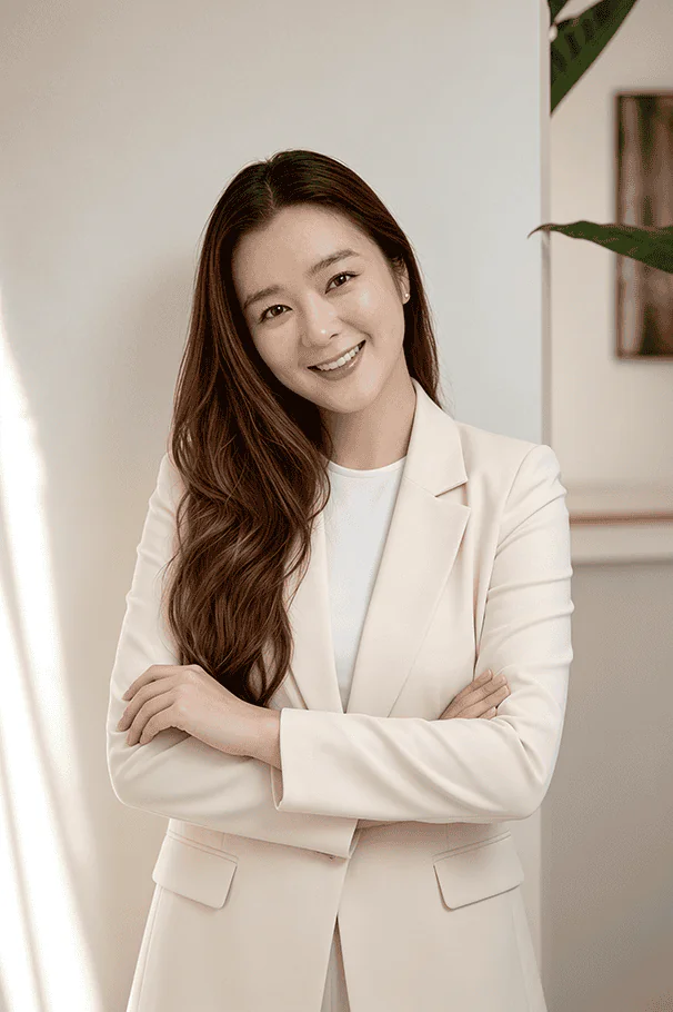Diane Elementa FF&E-Designer - Smiling woman in a beige blazer with arms crossed, standing indoors. | Elementa Interior Design Dubai